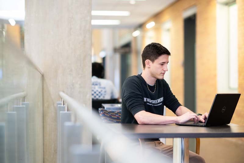 A photo of a student working on his laptop.